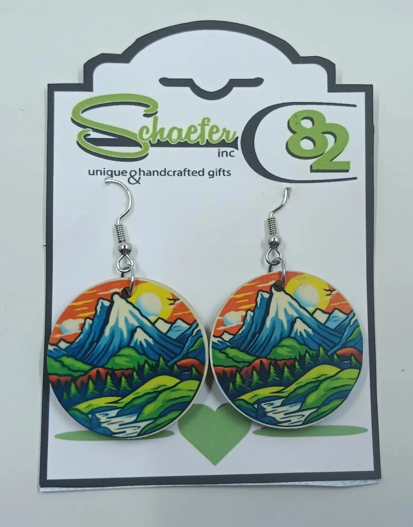 Colorful mountain earrings that has an orange sunset and river with green valleys