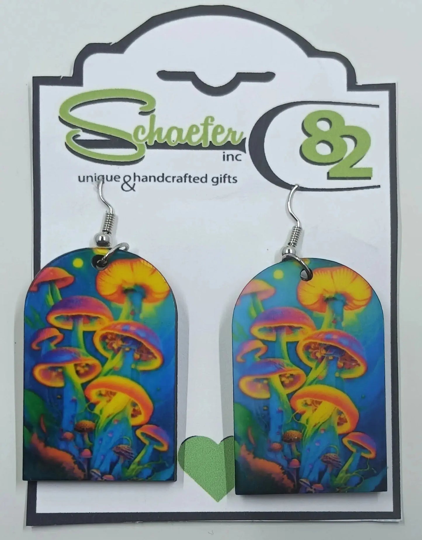 The handcrafted statement piece earrings are made with a psychedelic design on them with brightly colored mushrooms and dark sky in the background.