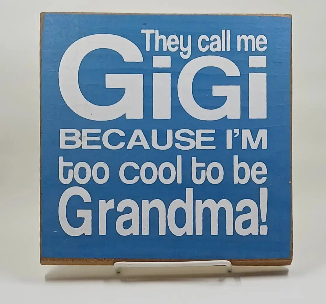 7 inch by 7 inch blue wooden sign that has white font on it and says "They call me Gigi because I'm too cool to be grandma"