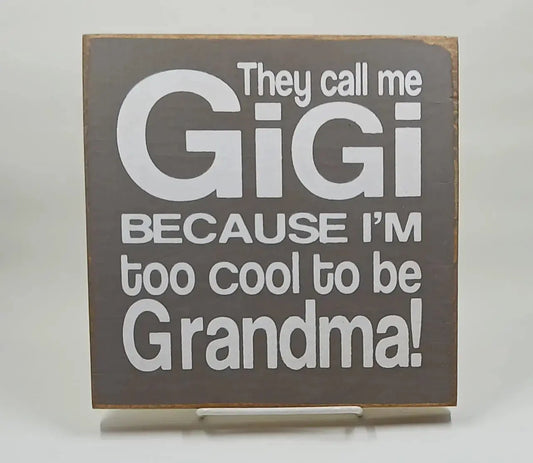 A 7 inch by 7 inch brown wooden sign with white lettering saying "they call me gigi because im too cool to be grandma
